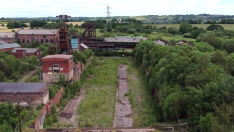 abandoned old overgrown coal mine industrial museum buildings aerial view fly past