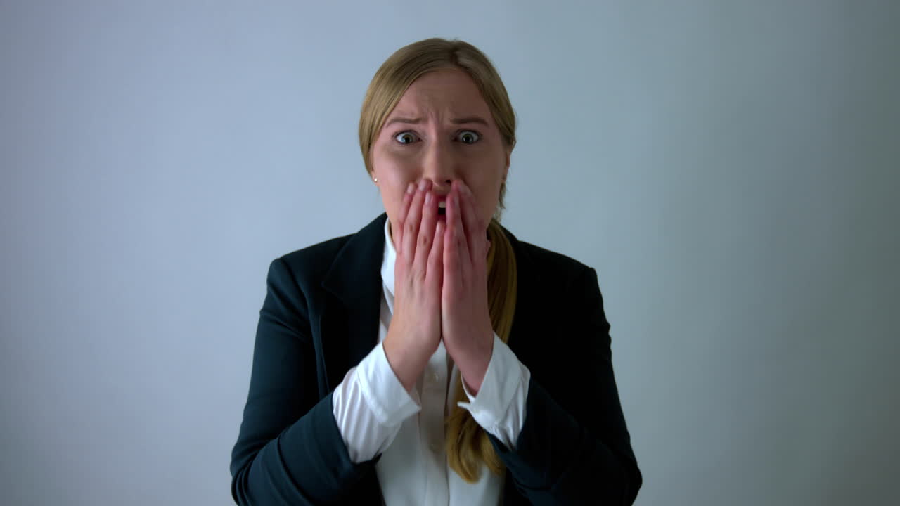 Stressed and scared businesswoman schiwing her shock to the camera