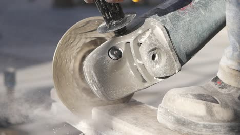 construction worker cutting a tile with an angle grinder