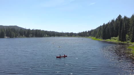 people kayaking in a mountain lake