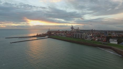 Aerial:-The-boulevard,-beach-and-city-of-Vlissingen-during-sunset