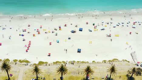 aerial view of a busy beach with people and umbrellas