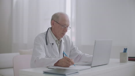 male-physician-is-reading-scientific-article-on-screen-of-notebook-surfing-internet-for-education-and-advanced-training