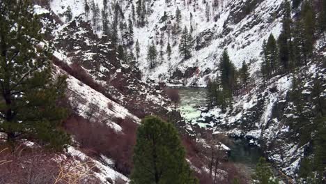 río que fluye a través de las montañas nevadas en el bosque nacional de boise en idaho, estados unidos