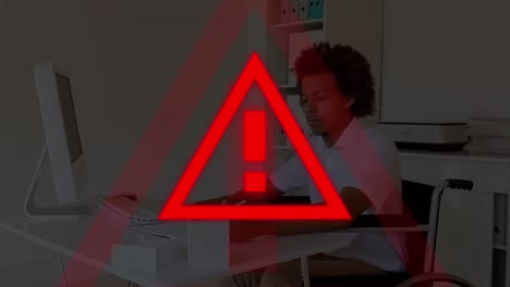 animation of exclamation in triangle over african american handicap man writing on notepad in office