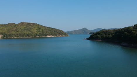 Drohnenüberflug-Des-Stausees-In-Hongkong,-Inselküste-Im-Hintergrund