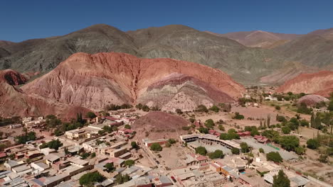 Aerial---Purmamarca,-Hill-of-Seven-Colors,-Argentina,-wide-rising-shot-backward