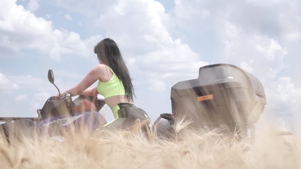 Woman riding ATV in a wheat field