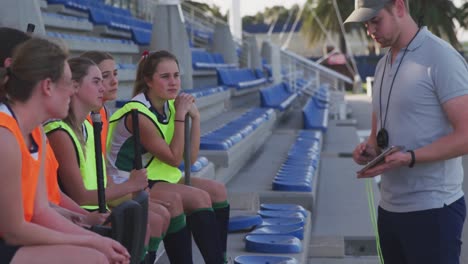 entrenador de hockey hablando con jugadoras