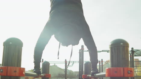 man doing handstand on parallel bars outdoor