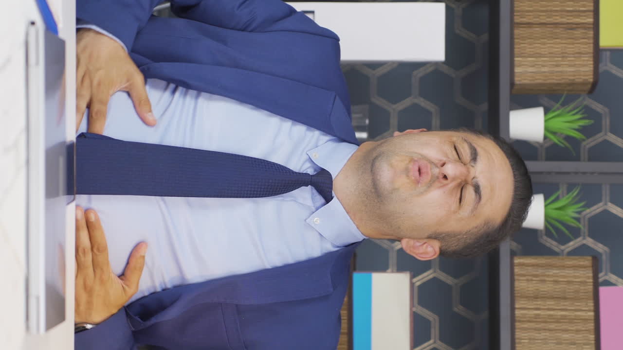 복통을  ⁇ 고 있는 사업가의 수직 비디오.