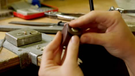 Jewelry designer holding loupe magnifier in workshop 4k