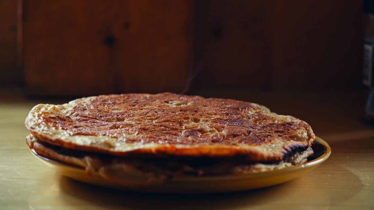 Smør smelter langsomt ned i en varm, gylden pandekage og fylder hytten med en følelse af stille hygge i Reinsjøen, Åfjord, Norge – Nærbillede.