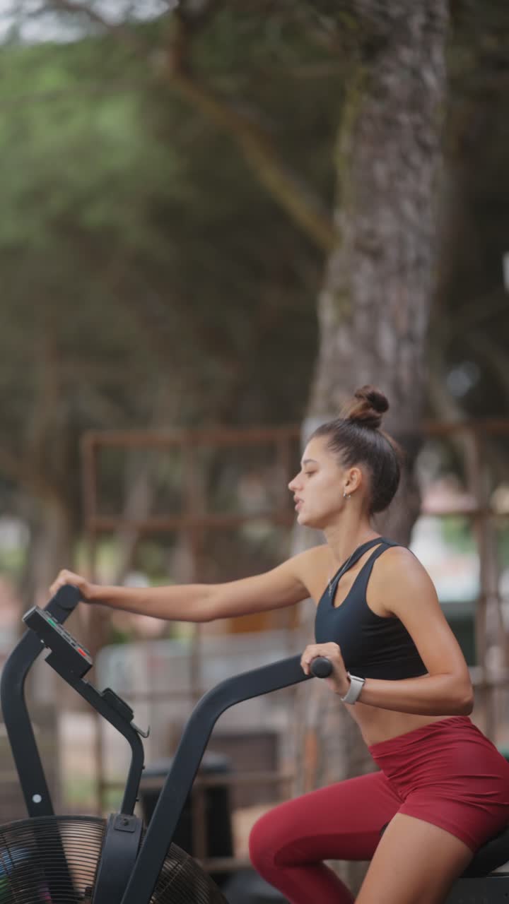 Woman exercising on an air bike outdoors