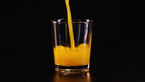 el jugo de naranja se vierte en un vaso transparente