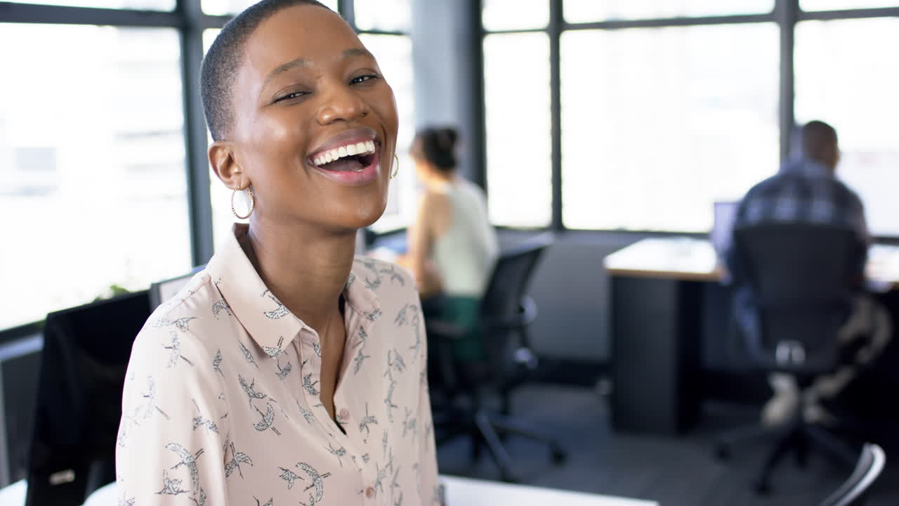 Portrait of smiling african american businesswoman in office, slow motion, copy space