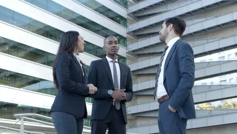 cheerful business people talking on street