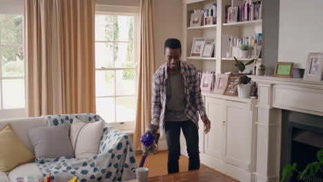 funny african american man dancing with vacuum cleaner at home celebrating success having fun dance cleaning living room doing chores on weekend 4k