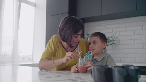 madre y hijo beben el jugo de los tubos