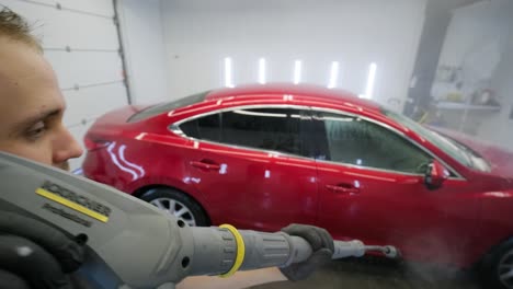 lavado de automóviles limpieza con espuma y agua a alta presión. coche rojo
