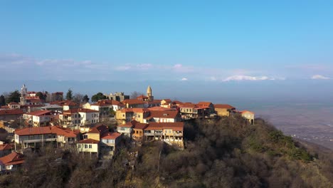 Vista-Aérea-Escénica-De-Un-Hermoso-Pueblo-En-La-Cima-De-Una-Colina-El-Día-De-Verano