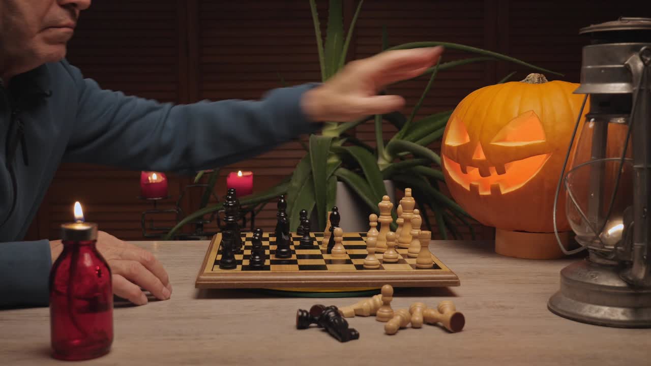 Man playing chess by candlelight with glowing Halloween jack-o’-lantern on table, cozy autumn evening atmosphere
