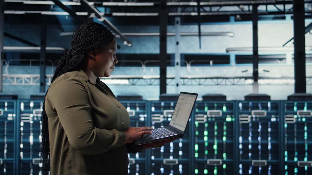 Admin in data center using app on laptop to ensure error free rigs networks