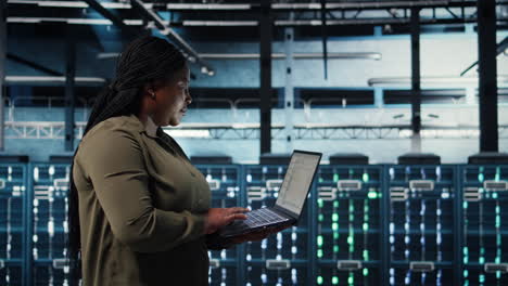 admin in data center using app on laptop to ensure error free rigs networks