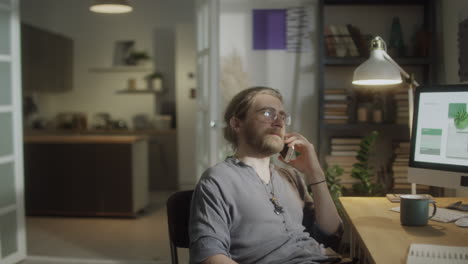 male freelancer calling on phone in evening