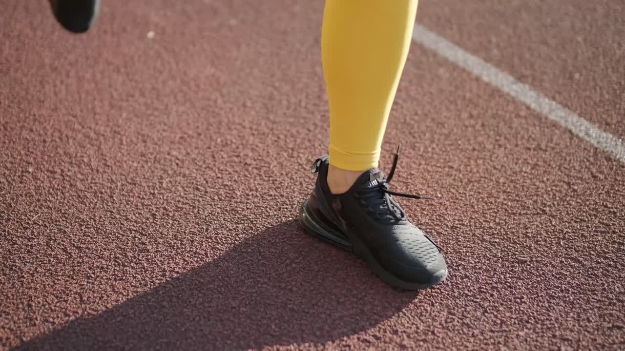 노란색 스포츠 의류 를 입고 야외 트랙 에서 달리는 여자