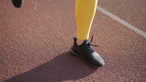 woman running on outdoor track in yellow sportswear