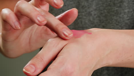 woman applying blush to wrist