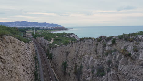 Im-Zeitraffer-Werden-Züge-Festgehalten,-Die-Aus-Dem-Tunnel-In-Richtung-Küstenstadt-Fahren,-Während-Die-Sonne-Aufgeht-Und-Der-Tag-Heller-Wird