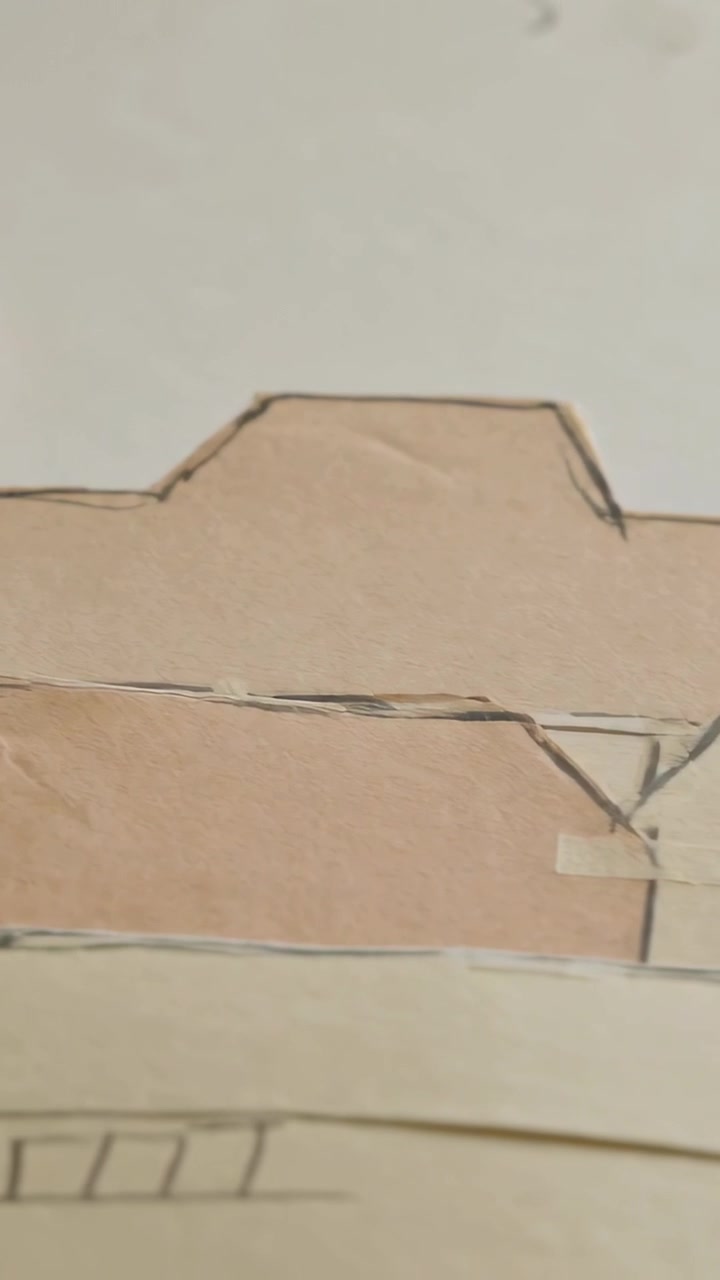 Vertical video: Panning camera across handcut paper tower roofs on back, showing tape and ink lines