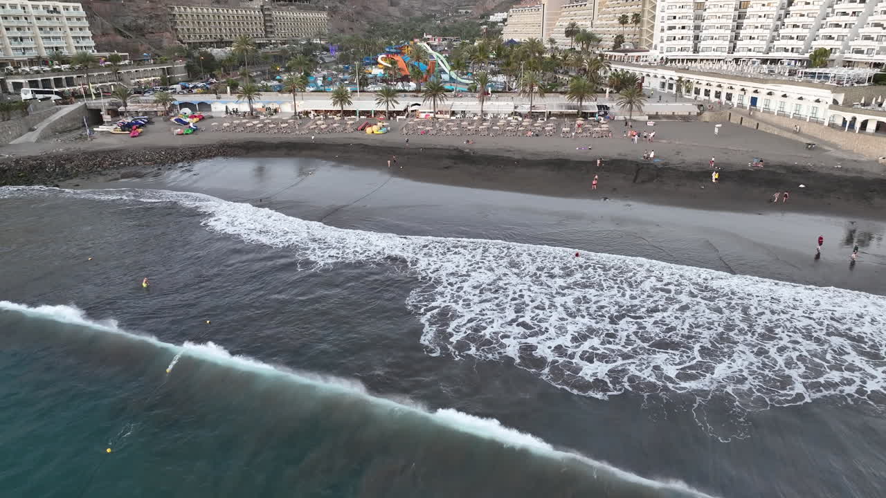 toma aérea a distancia de la playa de taurito en la isla de gran canaria y durante la puesta de sol