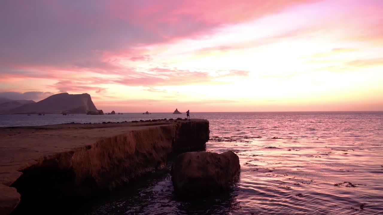 Solitary Figure at Sunset by the Ocean Coast