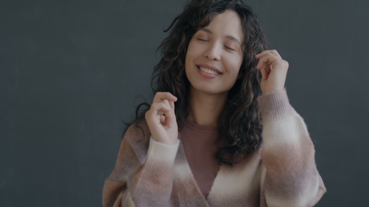 Una mujer con el cabello rizado sonriendo.