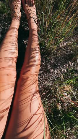 woman's legs in sandals relaxing in nature