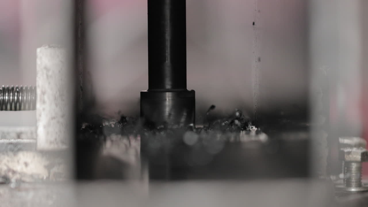 Drill Bit Drilling Hole Through Metal Plate - close up, slow motion