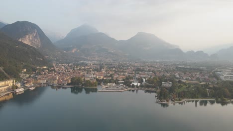 Vista-Aérea-De-La-Pintoresca-Ciudad-De-Riva-Del-Garda,-Frente-Al-Lago-Del-Lago-Di-Garda-Italia-En-La-Mañana-De-Verano,-Disparo-De-Drone