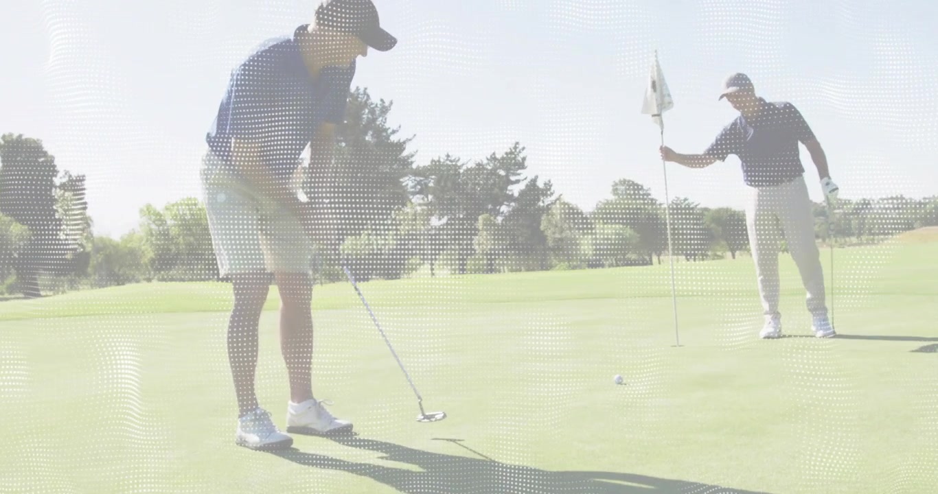 Dojrzały golfista wchodzący na green, celujący i uderzający piłkę, z partnerem trzymającym chorągiewkę.
