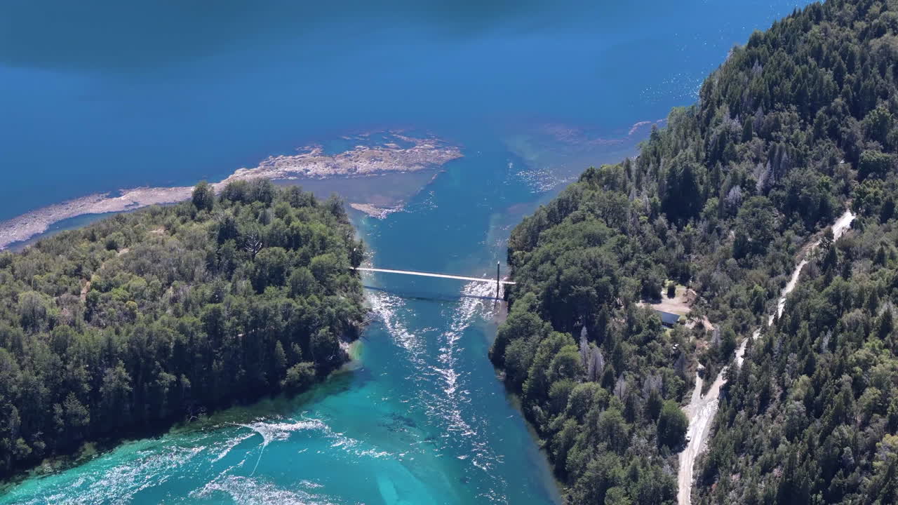 A stunning high aerial view of the suspension bridge spanning the River Arrayanes in Parque Nacional Los Alerces, Argentina, showcasing the lush landscapes and natural beauty of the region.