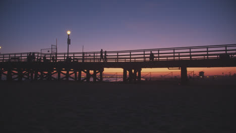 silhouettes and a pier under beautiful skies