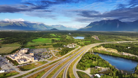 Alaska stunning travel views. Lush greenery, winding roads, and tranquil lakes under a dramatic sky in Alaska&#039;s picturesque landscape