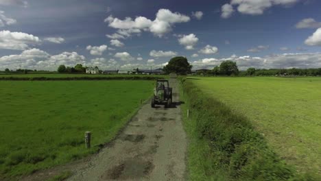 Aerial-drone-shot-of-farmer-driving-a-tractor-in-Ireland