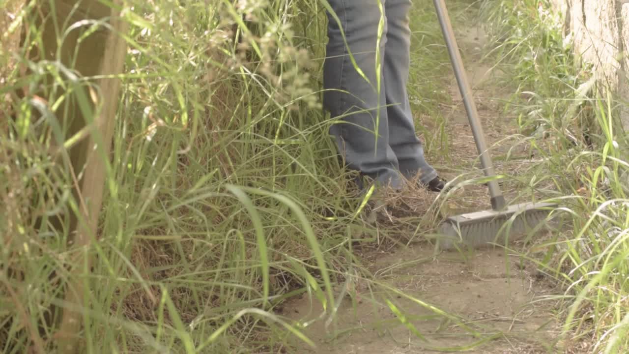propietario barriendo camino cubierto con escoba