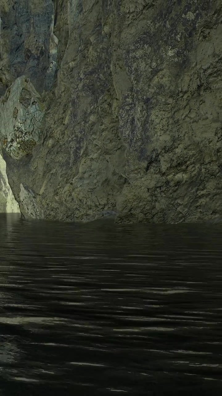 Water reflects rocks on cliff face at sunset near a calm lake