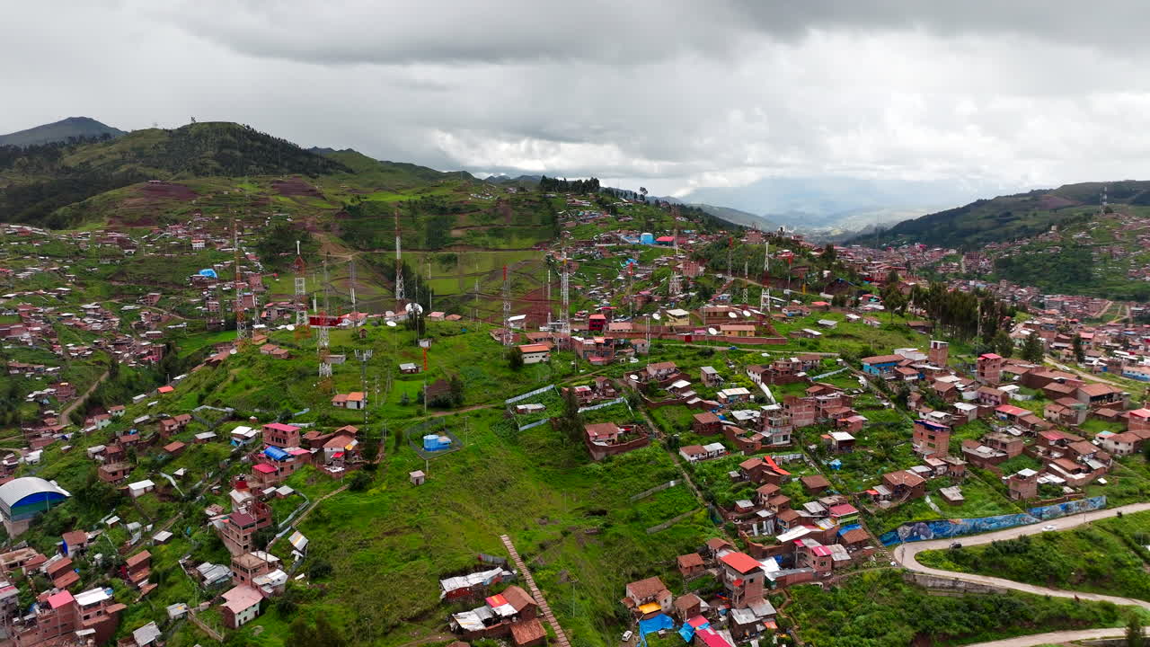 Radio antenna towers atop hillside of mountainous Cusco city in Peru. Aerial