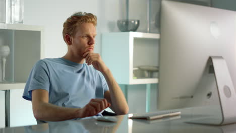 thoughtful businessman check data at home closeup. man work on desktop computer.