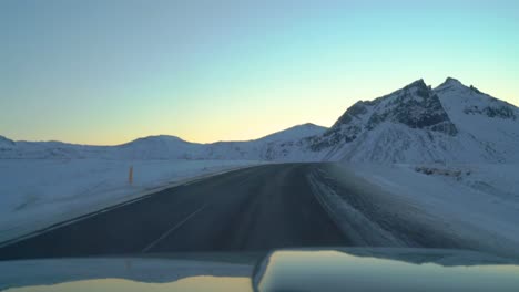 conduciendo por carreteras heladas en islandia en invierno hacia el amanecer en febrero
